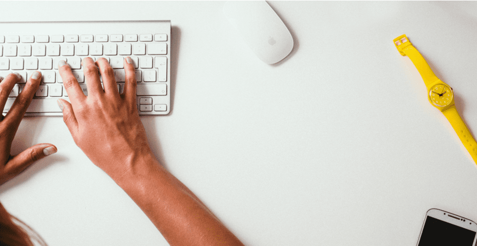 Hands typing on Mac keyboard